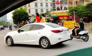 2 Bé Gái Ngồi Đùa Giỡn Trên Nóc Ô Tô Chạy Giữa Phố